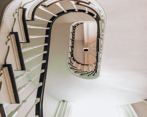 Person walking up stairs in a bright residential building interior
